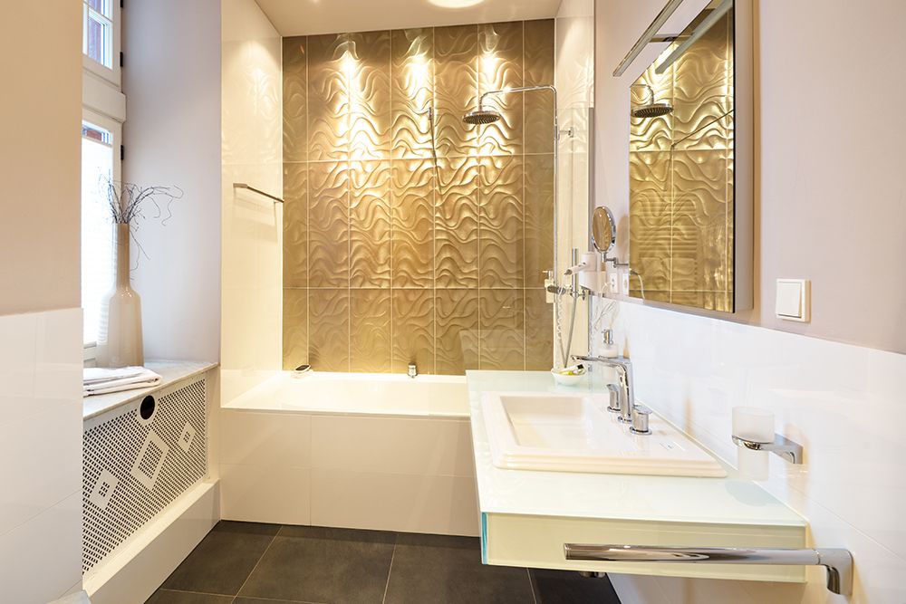 Modernes Badezimmer mit Badewanne, Glasdusche, großem Waschbecken und beige gemusterter Akzentwand.