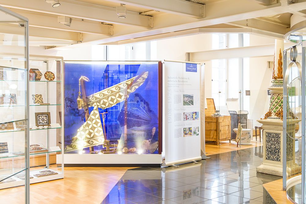Explore our museum's fascinating display, featuring a large, intricately designed boat model in a glass display case. Surrounding the model are information boards and smaller artifacts in display cases, making it one of our must-visit destinations when visiting local attractions.